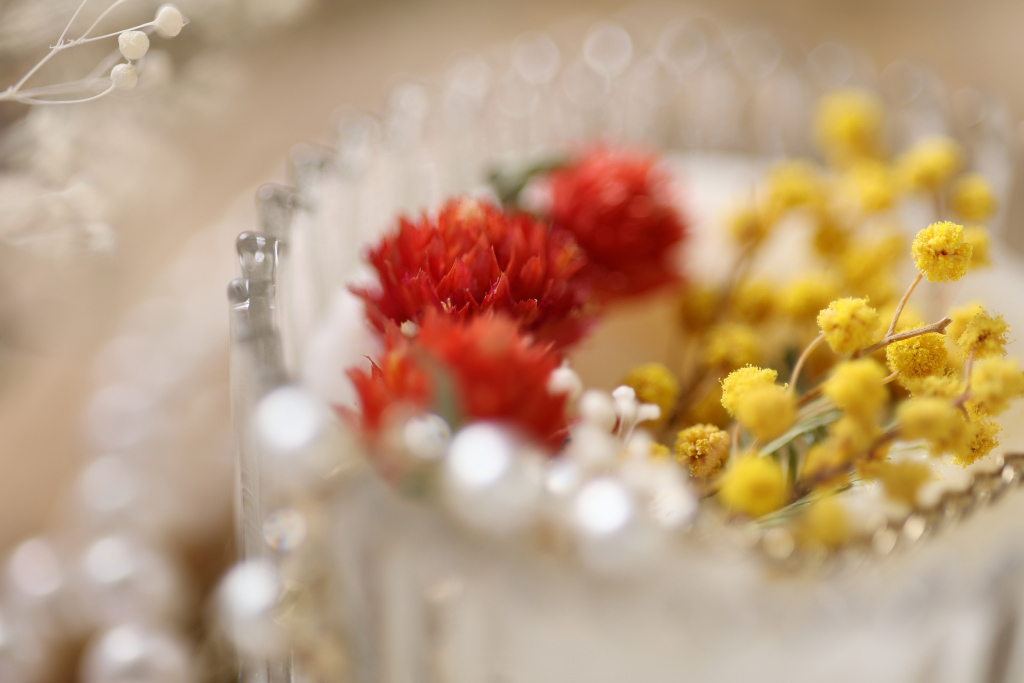 Close-up of red and yellow flowers in glass vase