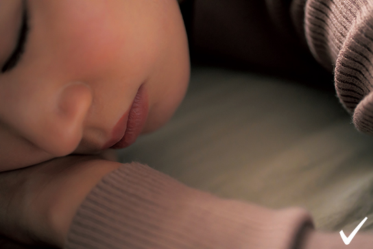 Model resting head on hands, close-up